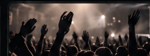 Concert crowd with raised hands and stage lights